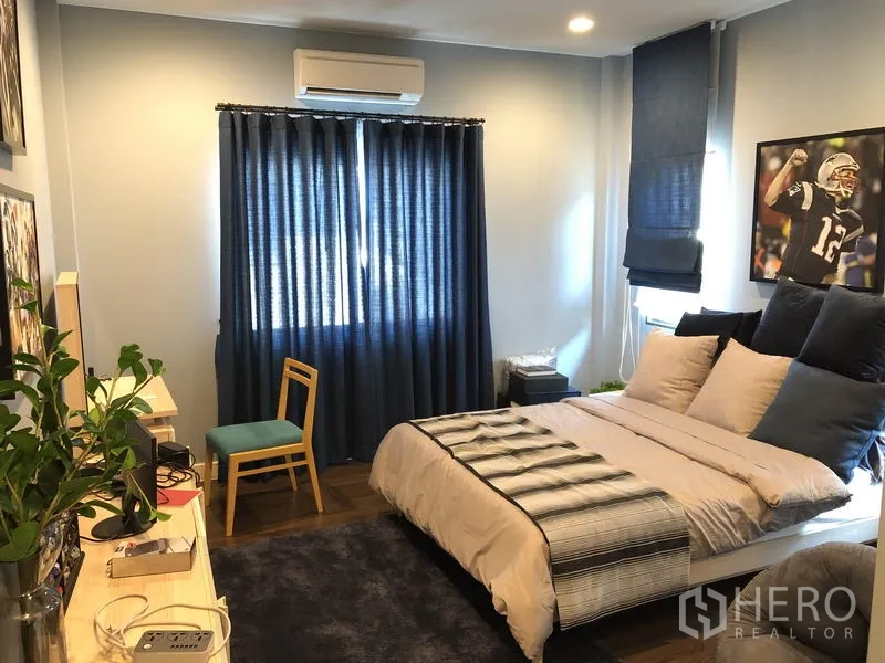 Detached House for rent in Bang Kapi, Bangkok - Guest bedroom with double bed, desk, blue curtains and air conditioner.