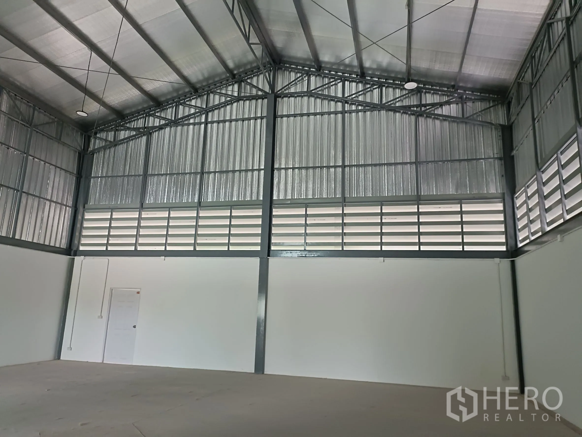 Warehouse for rent or sale in Bang Yai, Nonthaburi - Spacious warehouse interior with high gable steel roof, insulation and louvered ventilation panels.