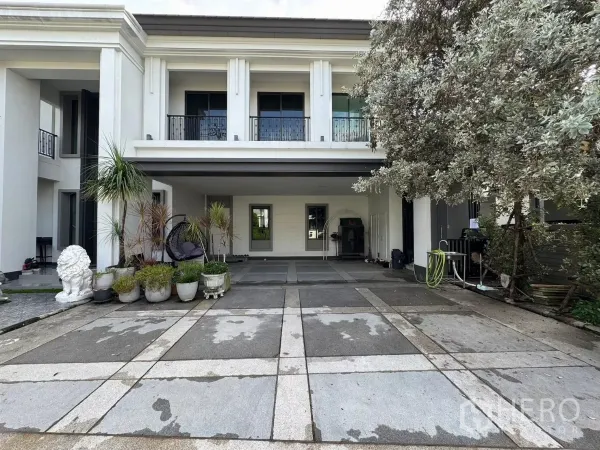 Detached House for sale in Mueang Pathum Thani, Pathum Thani - Covered carport and entrance with potted plants beside a large shade tree.
