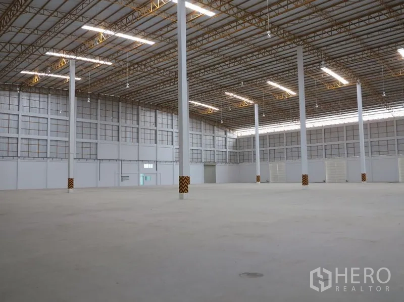 Warehouse for rent in Lopburi - Open factory floor with smooth concrete, skylights and a grid of support columns