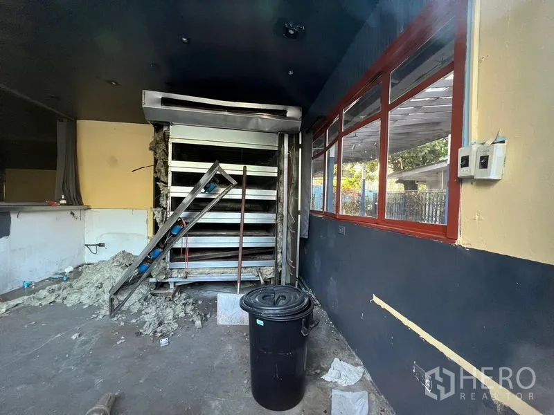 Retail Space for rent in Watthana, Bangkok - Back-of-house room under renovation with metal shelving and utility lines.