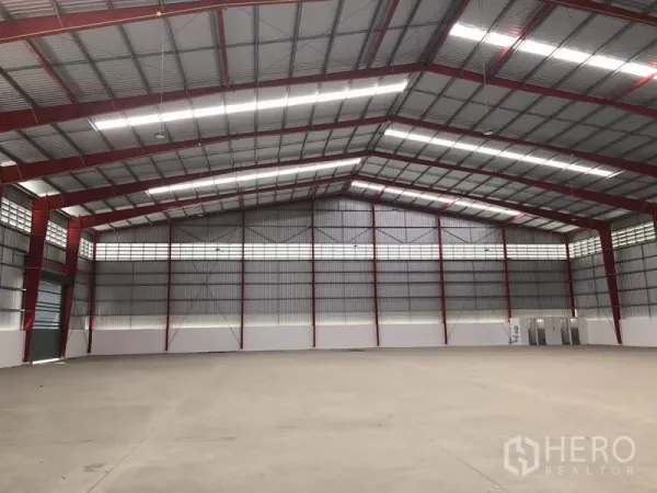 Warehouse for rent in Pak Kret, Nonthaburi - Clear-span storage hall with multiple roller shutters and bright roof lights.