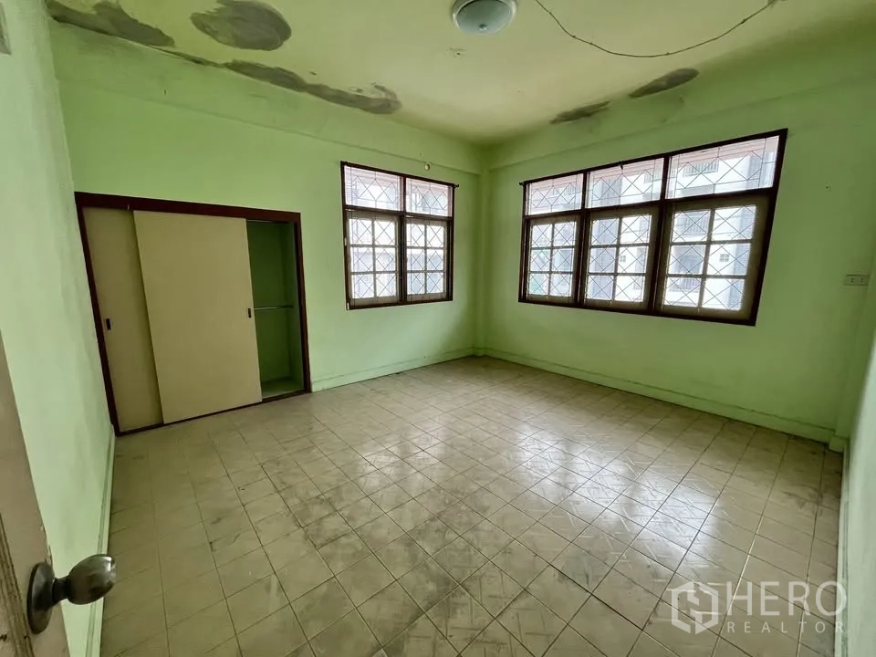 Detached House for rent in Suan Luang, Bangkok - Spacious bedroom with corner windows and built-in sliding closet.