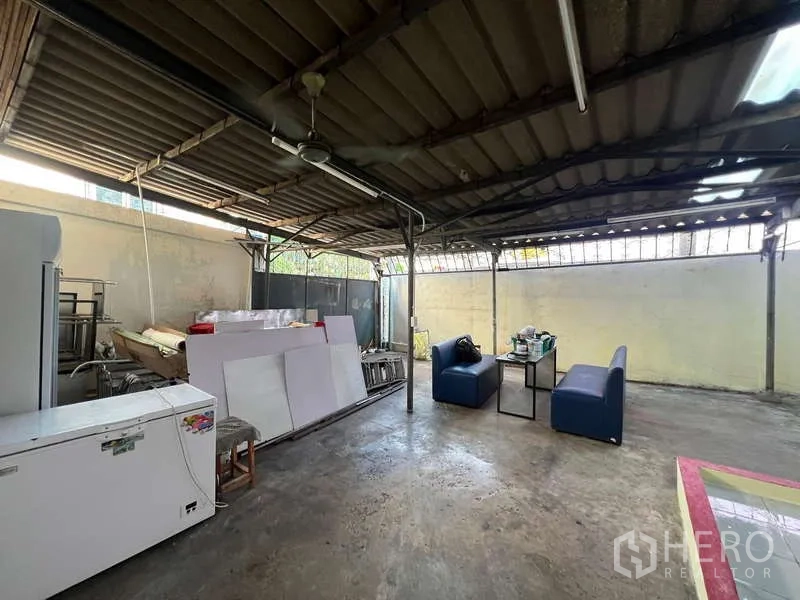 Shophouse for rent in Suan Luang, Bangkok - Covered back patio with metal roof, seating and storage area.