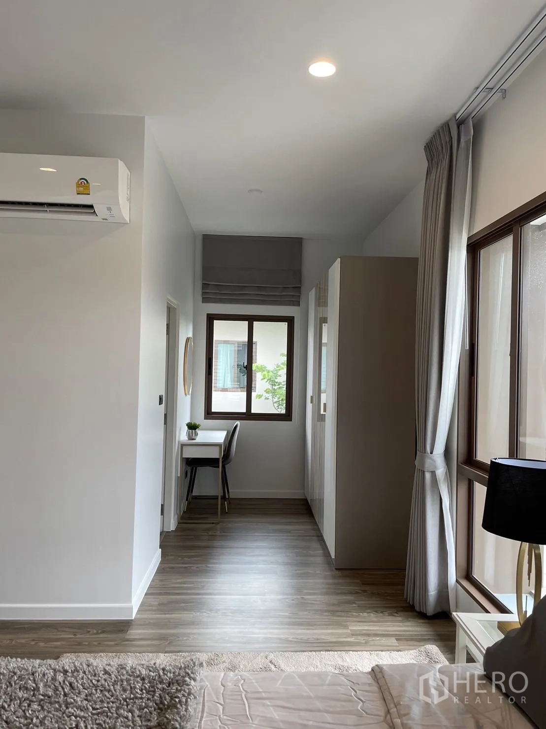 Detached House for rent in Bang Kapi, Bangkok - Master suite corridor with desk area, wardrobe, and window.