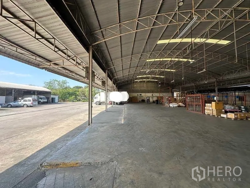 Warehouse for rent in Lam Luk Ka, Pathum Thani - Open-plan high-clearance warehouse interior with skylight panels and loading edge.