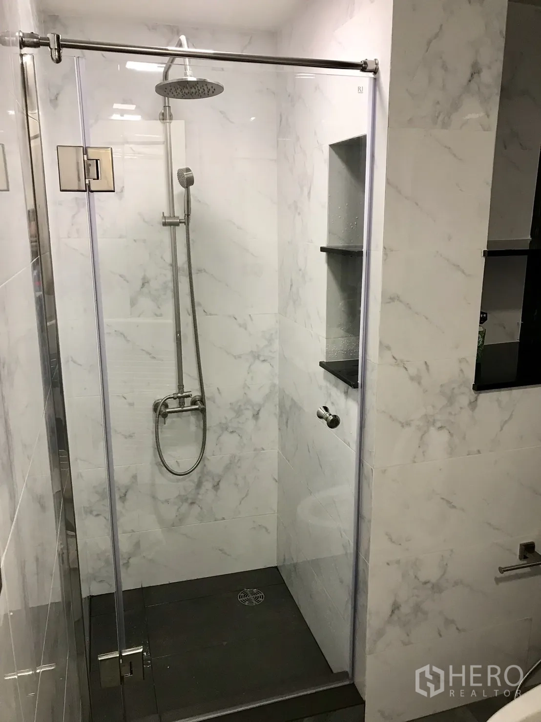 Condominium for rent or sale in Khlong Toei, Bangkok - Second bathroom walk-in shower with rain showerhead, glass door and marble-effect tiles.