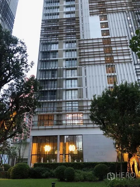 Condominium for rent in Khlong Toei, Bangkok - Modern high-rise condominium exterior with landscaped garden.
