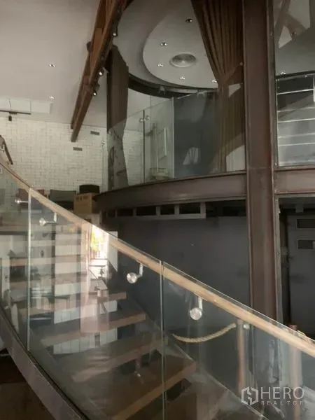 Retail Space for rent in Watthana, Bangkok - Curved glass staircase leading to mezzanine rooms with spotlights and modern finishes.
