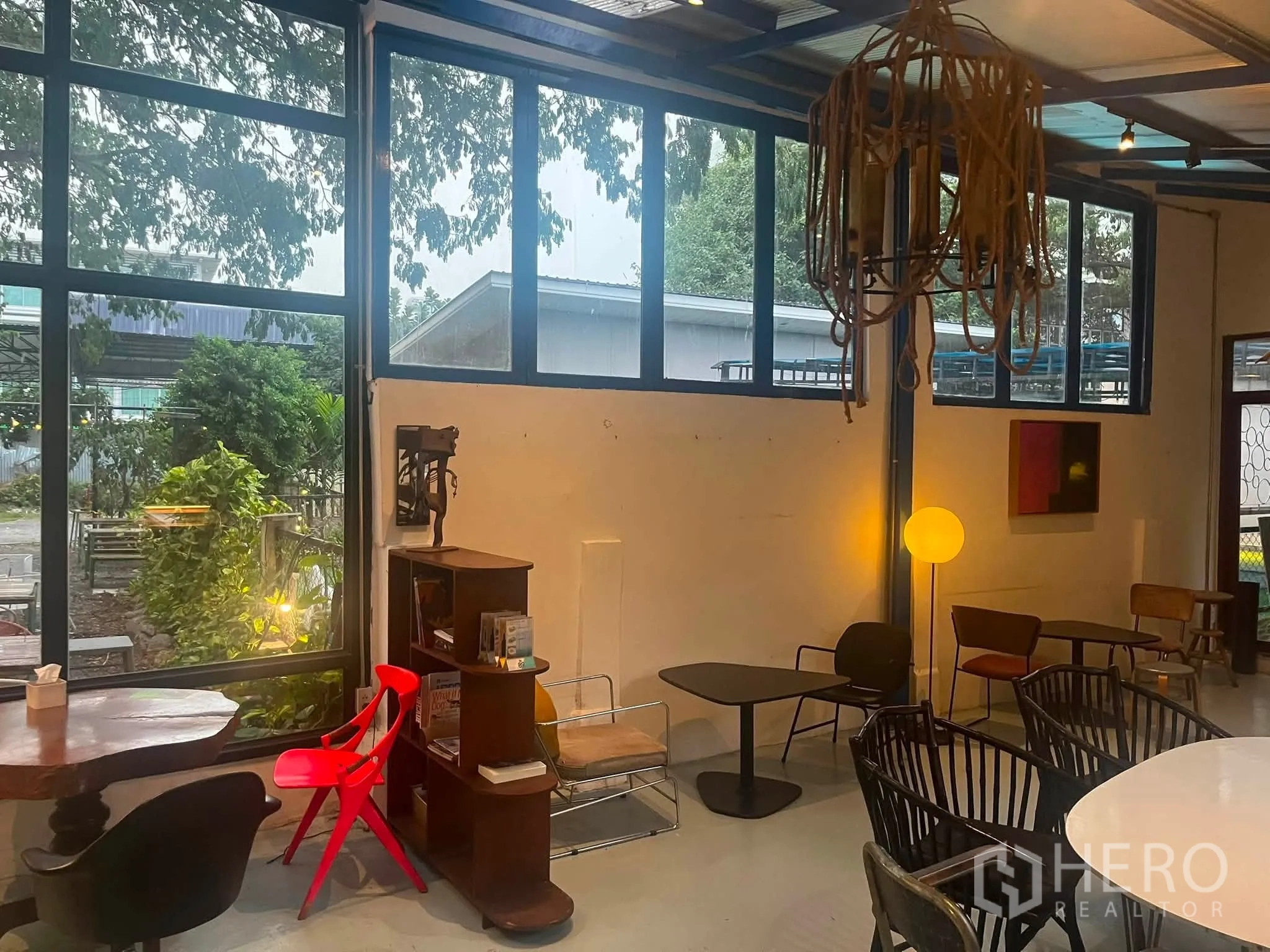 Retail Space for rent in Watthana, Bangkok - Corner of the retail area with large windows, low tables, a floor lamp, and modern chairs.