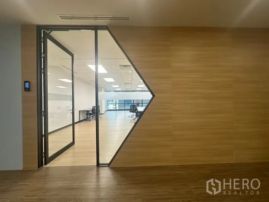 Office Space for rent in Chatuchak, Bangkok - Modern office entrance with triangular glass panel leading to an open workspace.