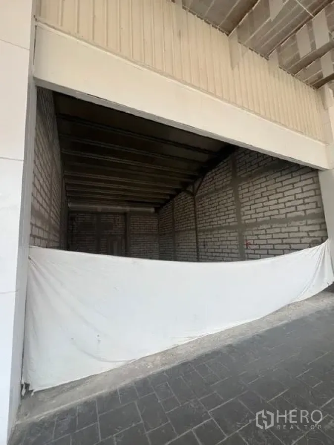 零售空间 出租在Khlong Toei, Bangkok - 宽阔店面位于雨棚下，前场为混凝土地坪，内部毛坯待装修。