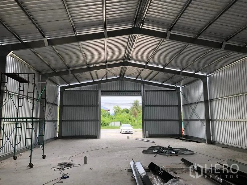 Warehouse for rent in Bang Yai, Nonthaburi - Warehouse hall with twin loading doors, steel trusses and translucent roof panels.