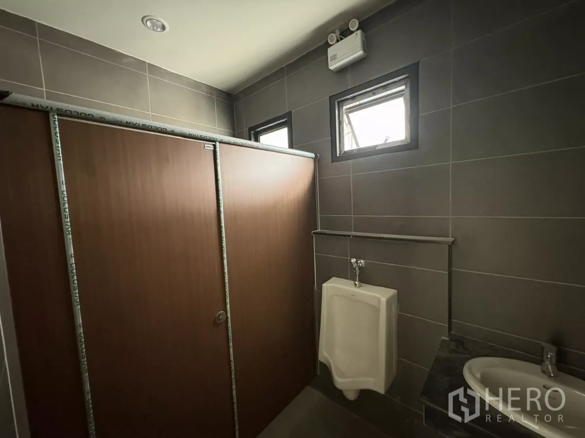 Factory for rent in Bang Pakong, Chachoengsao - Male restroom with urinal, sink and ventilation windows.