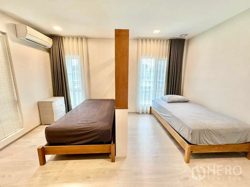 บ้าน ให้เช่าหรือขายในPrawet, Bangkok - เตียงเดี่ยวสองฝั่งกั้นด้วยผนังไม้กลางห้อง มีหน้าต่างรับแสงและผ้าม่าน