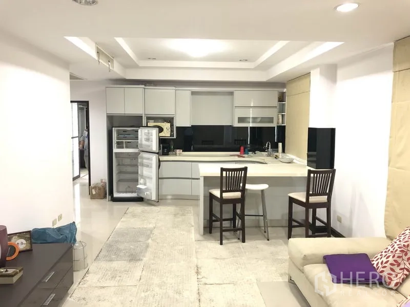 Home Office for rent in Wang Thonglang, Bangkok - Modern open kitchen with island, built-in cabinetry, open refrigerator and bar stools.