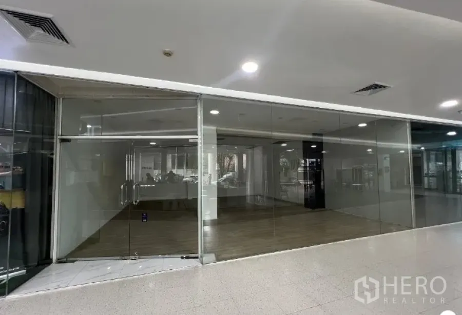 Retail Space for rent - Glass-fronted retail shop with double doors in a modern indoor commercial building.