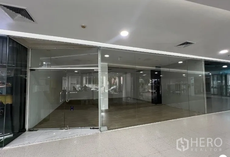 Retail Space for rent - Glass-fronted retail shop with double doors in a modern indoor commercial building.