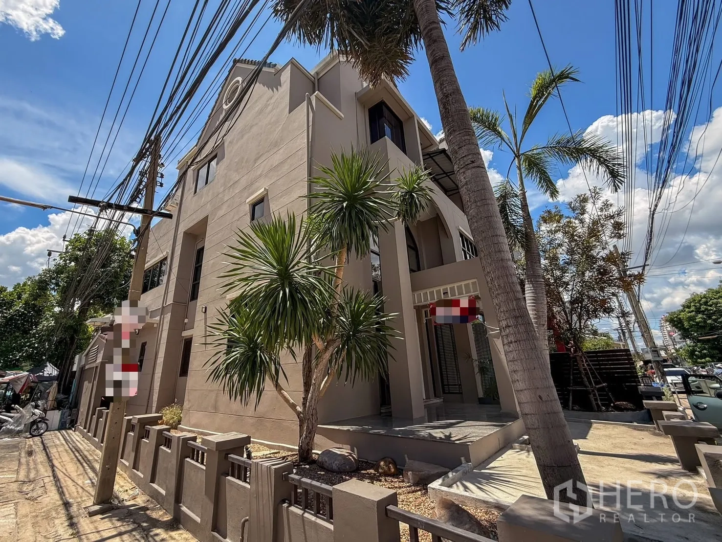 Home Office for rent in Wang Thonglang, Bangkok - Street view of the home office exterior with driveway and tropical plants.