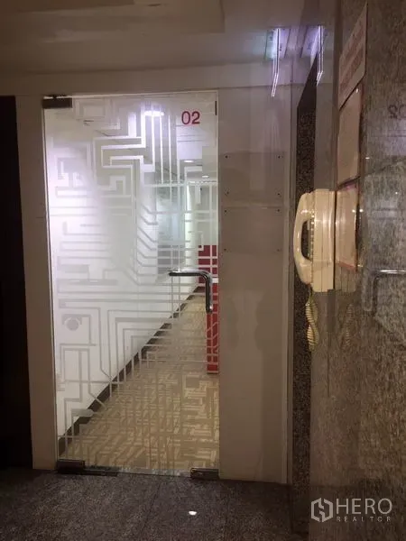 Office Space for rent in Watthana, Bangkok - Building corridor with frosted patterned glass door and intercom access.