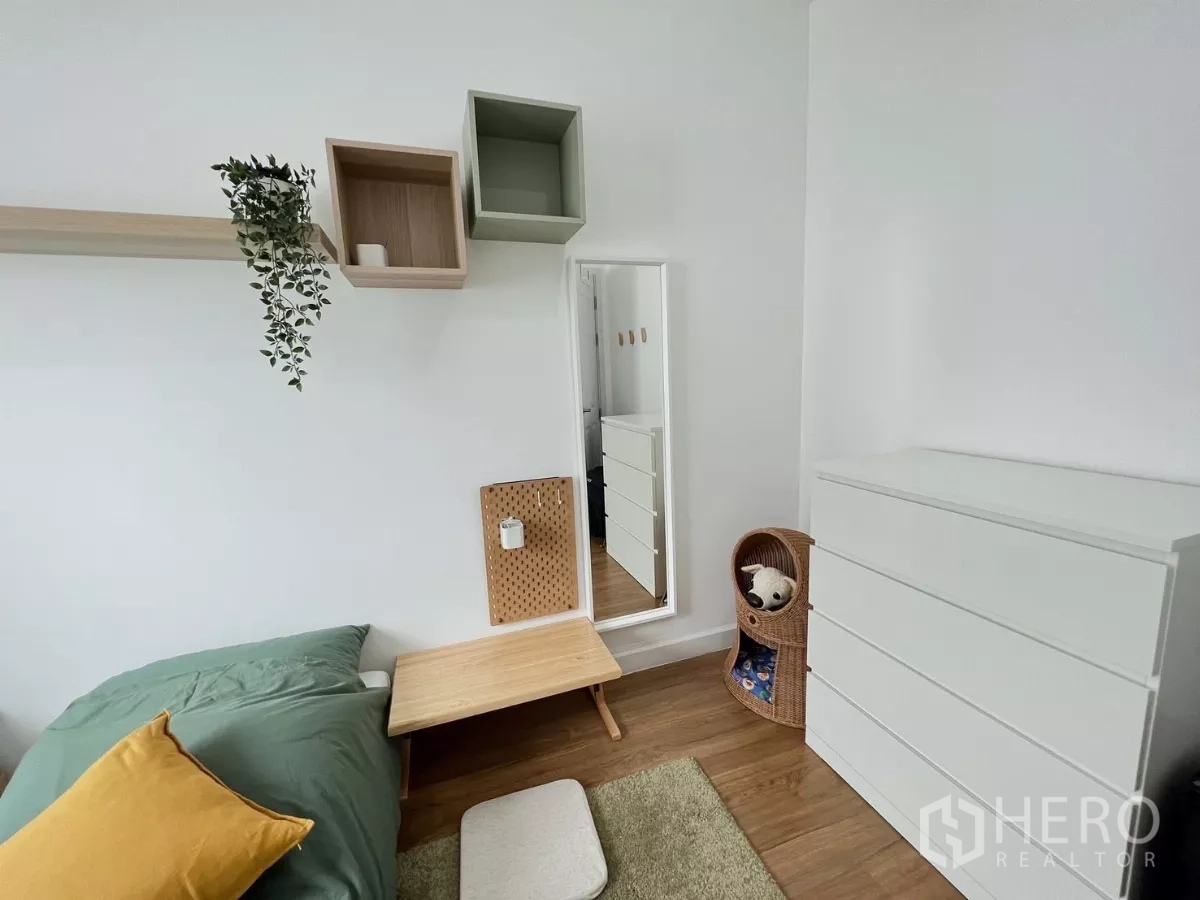 Detached House for rent or sale in Khlong Luang, Pathum Thani - Minimal guest bedroom corner with white dresser and wall shelves.