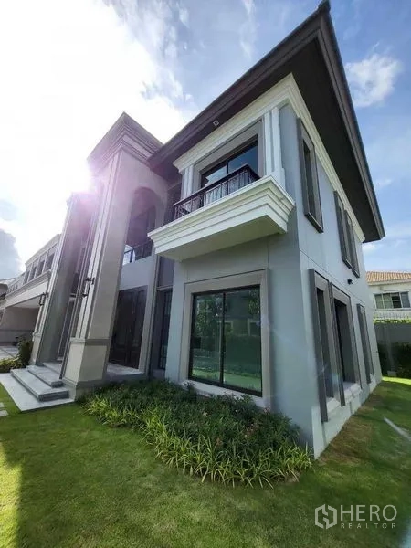 独立式住宅 出售在Prawet, Bangkok - 两层住宅外观，落地窗、小阳台与草坪园景雅致。