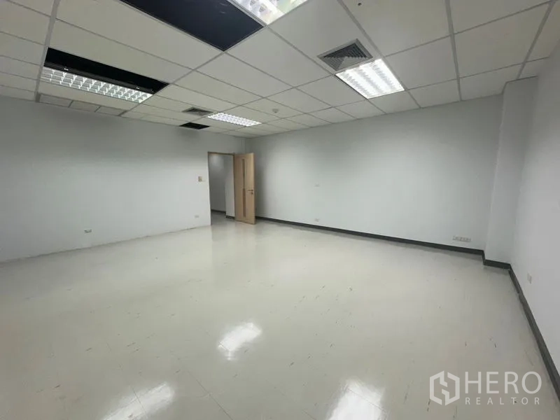 Office Space for rent in Bang Rak, Bangkok - Empty internal office room with doorway access and bright overhead lights.