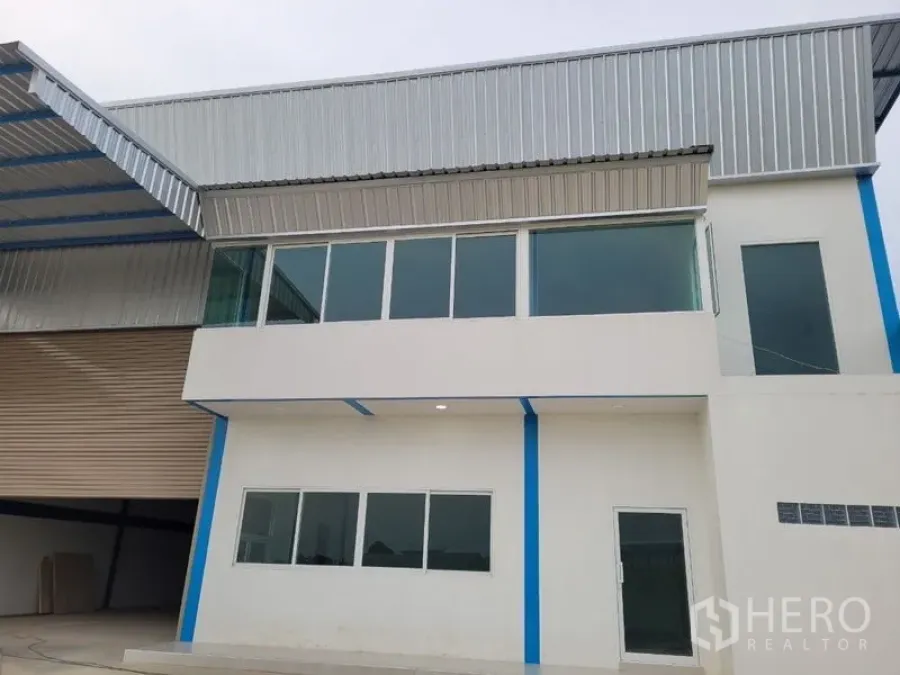 Factory for rent or sale in Khlong Luang, Pathum Thani - Modern factory exterior with glass-fronted office and metal roof in Khlong Luang.