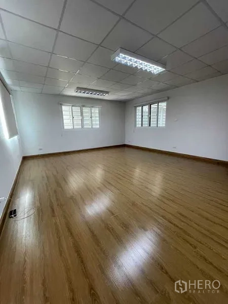 Warehouse for rent in Lam Luk Ka, Pathum Thani - Bright upstairs office room with wood-style flooring and fluorescent lighting.