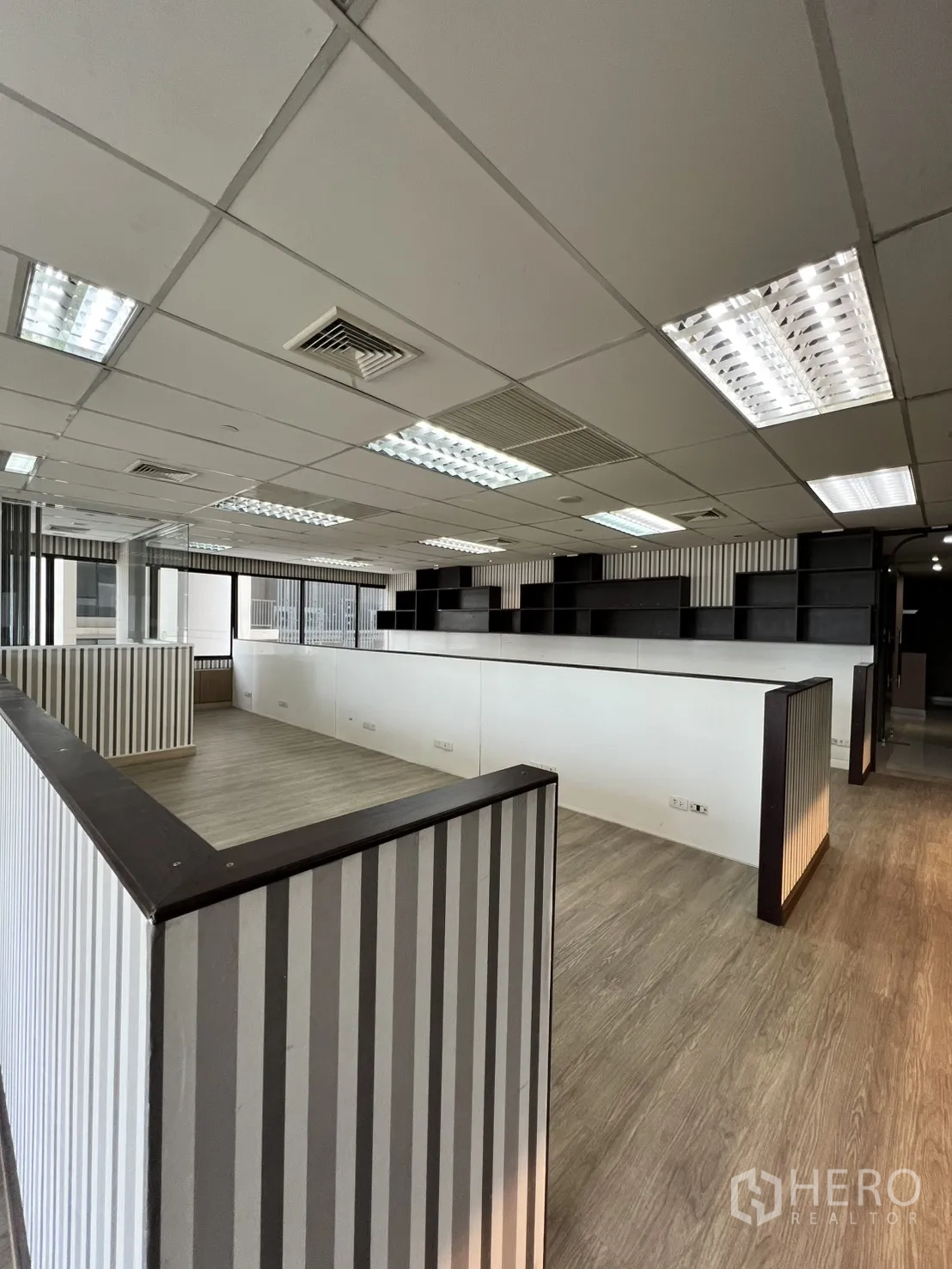 Office Space for rent in Watthana, Bangkok - Open-plan area with built-in work partitions and shelving units.