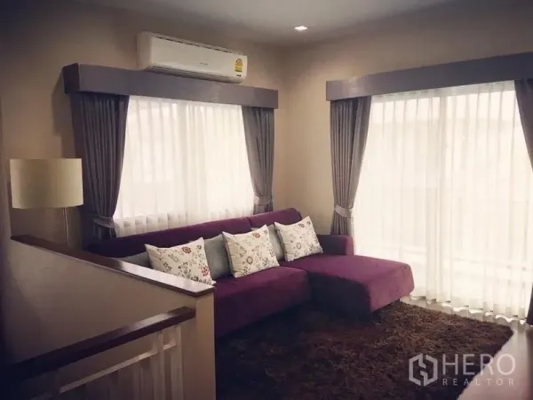 Detached House for sale - Upstairs family room with purple sectional sofa, large windows, and air conditioner.