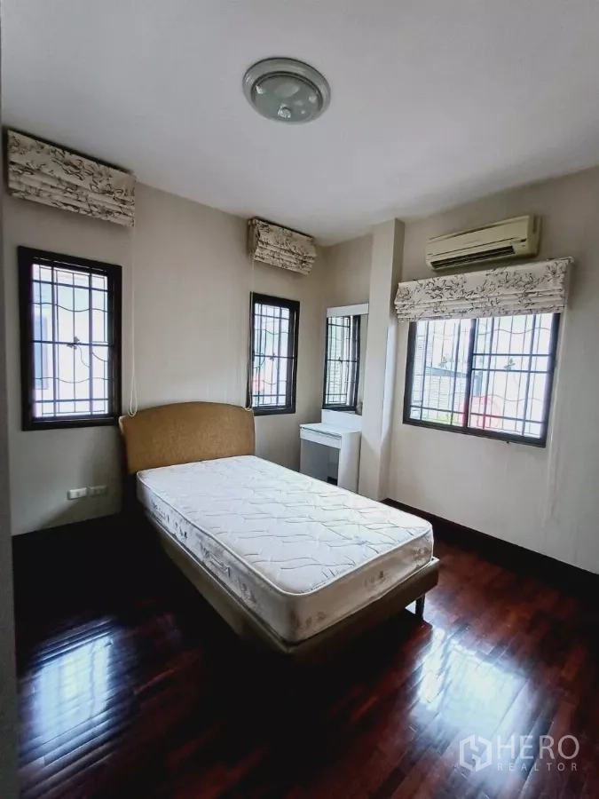 Detached House for rent or sale in Mueang Nonthaburi, Nonthaburi - Cozy bedroom with corner windows, air conditioner and abundant natural light.