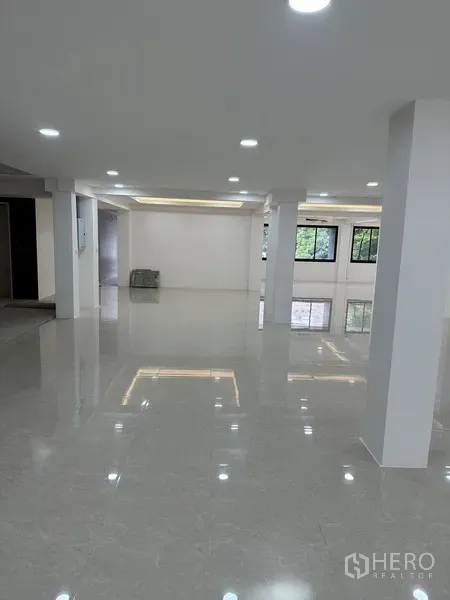Office Space for rent or sale in Huai Khwang, Bangkok - Large office hall with recessed ceiling lights and glossy tiled flooring.