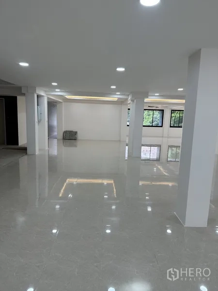Office Space for rent or sale in Huai Khwang, Bangkok - Large office hall with recessed ceiling lights and glossy tiled flooring.