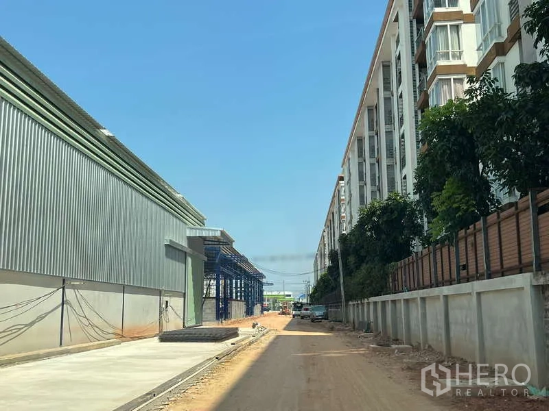 Warehouse for rent in Lat Krabang, Bangkok - Access road between warehouse buildings and apartments leading to the industrial site.