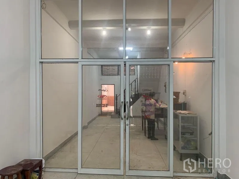 Shophouse for rent in Khlong Toei, Bangkok - Full-height glass storefront doors leading into a clean open-plan shop space.