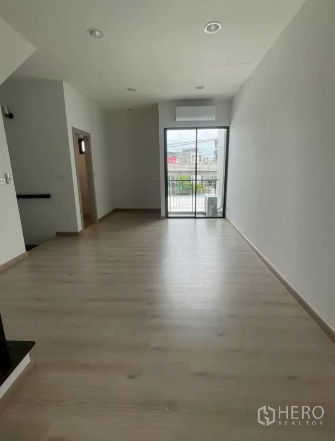 Home Office for rent in Bueng Kum, Bangkok - Bedroom or office with wood floors, sliding glass door to a balcony, and air conditioner.