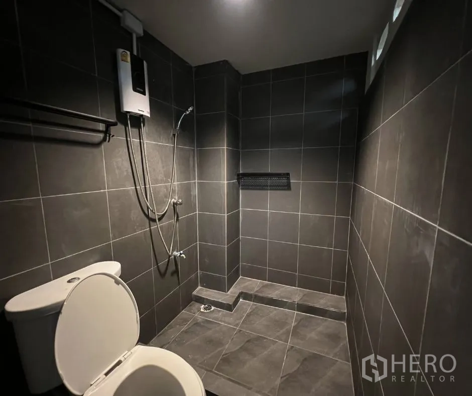 Townhouse for rent - Renovated bathroom with gray tiles, shower area and water heater.
