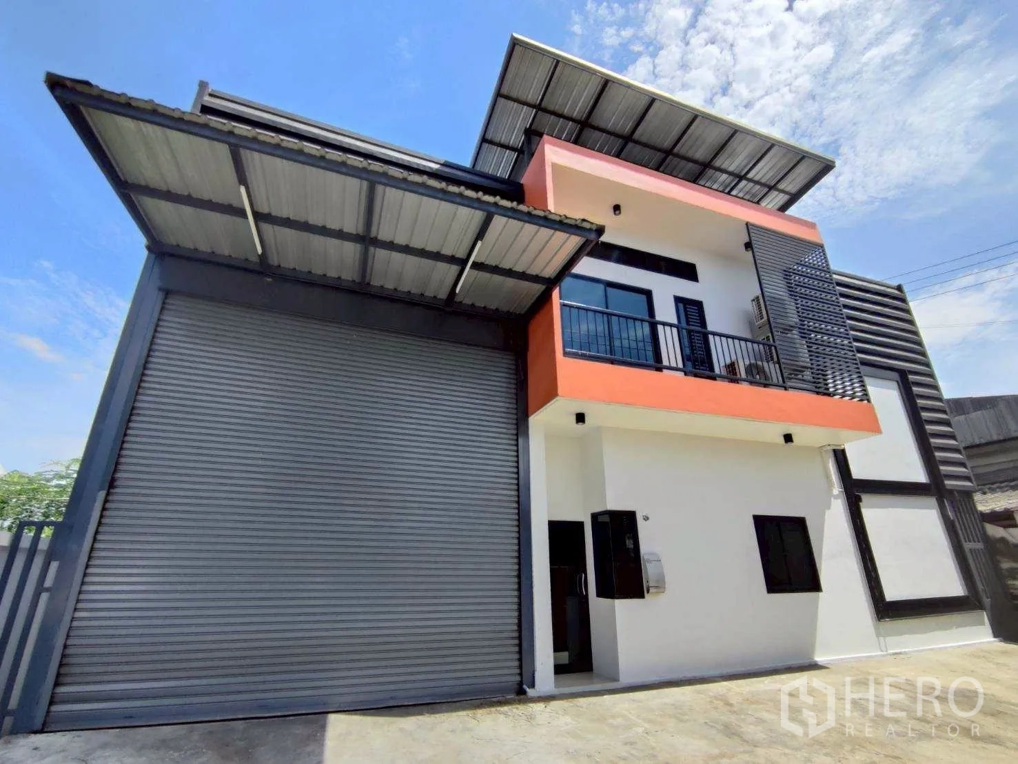 Warehouse for rent in Lam Luk Ka, Pathum Thani - Front view with office balcony beside the large loading door and canopy.