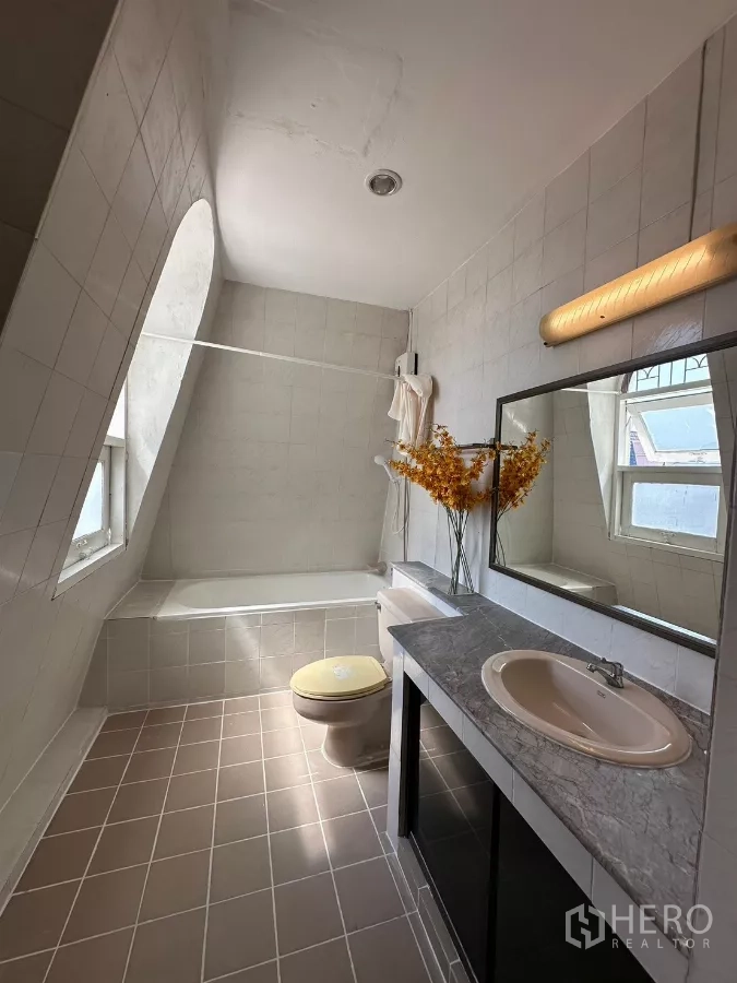 Home Office for rent in Suan Luang, Bangkok - Tiled bathroom with bathtub, large mirror, and window.