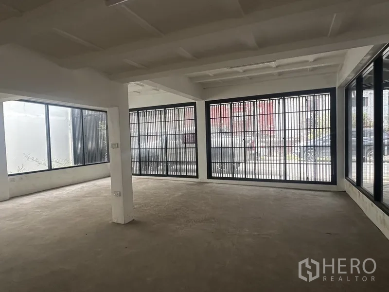 Home Office for rent or sale in Bang Na, Bangkok - Bright corner area with floor-to-ceiling windows and metal grilles.