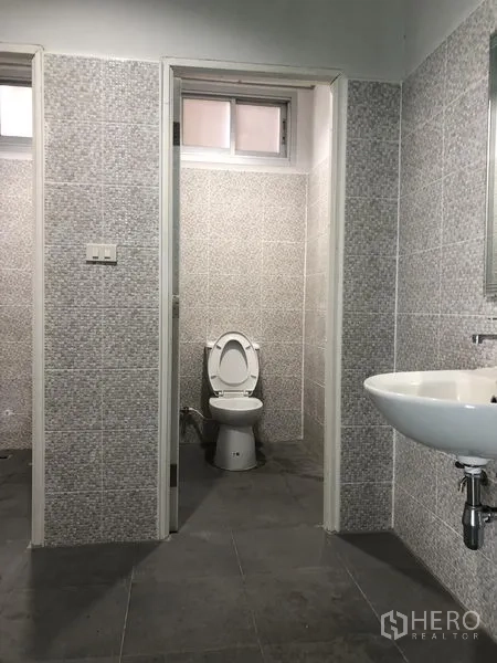 Factory for rent or sale in Bang Phli, Samut Prakan - Tiled restroom featuring a toilet cubicle and wall-mounted sink.
