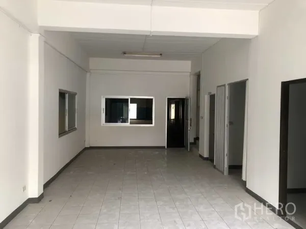 Factory for rent in Khlong Luang, Pathum Thani - Ground-floor office or showroom space with tiled flooring and interior windows.
