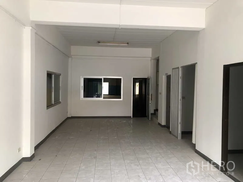 Factory for rent in Khlong Luang, Pathum Thani - Ground-floor office or showroom space with tiled flooring and interior windows.