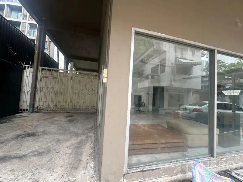 办公空间 出租 - 带顶棚的车道与卷闸门，紧邻玻璃外立面