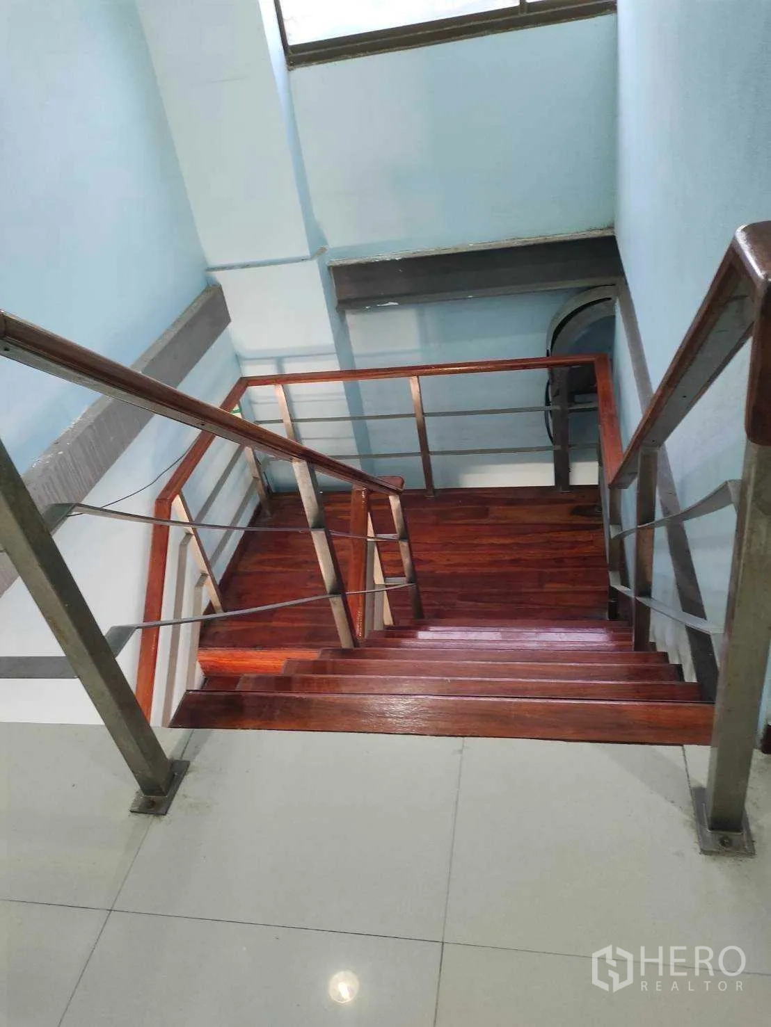 Factory for sale in Nikhom Phatthana, Rayong - Interior staircase with wooden steps and stainless-steel handrails in the office block.