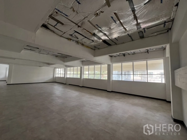 Office Space for rent in Watthana, Bangkok - Bright office space with wall‑to‑wall windows and exposed insulated ceiling panels.