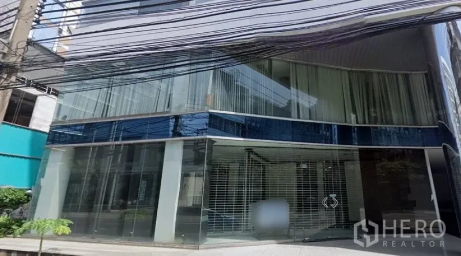 Retail Space for rent in Sathon, Bangkok - Street-level retail unit with curved floor-to-ceiling glass façade and security grille.