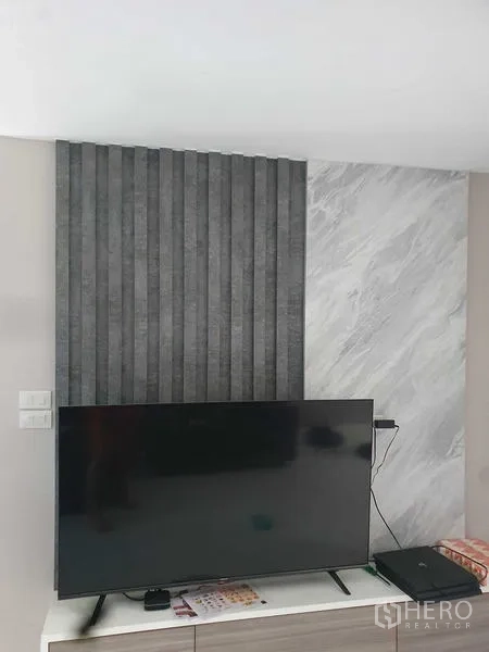 Home Office for rent in Suan Luang, Bangkok - Living room TV feature wall with textured panels and marble-look finish.