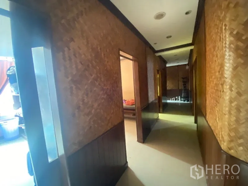 办公空间 出租在Khlong Toei, Bangkok - 走廊采用编织墙面与筒灯，通向多间独立房间。